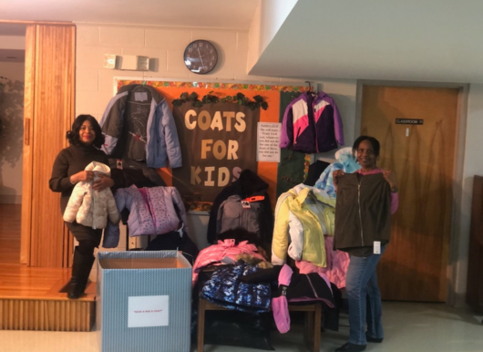 members pose with coats collected for food drive